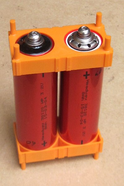 Zwei LiFePO4–Akkus in passenden Kunststoffhaltern.