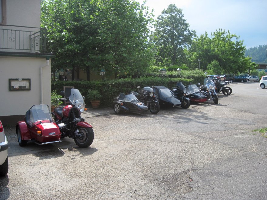 Im Hof eines Gasthauses parken einige Motorradgespanne.
